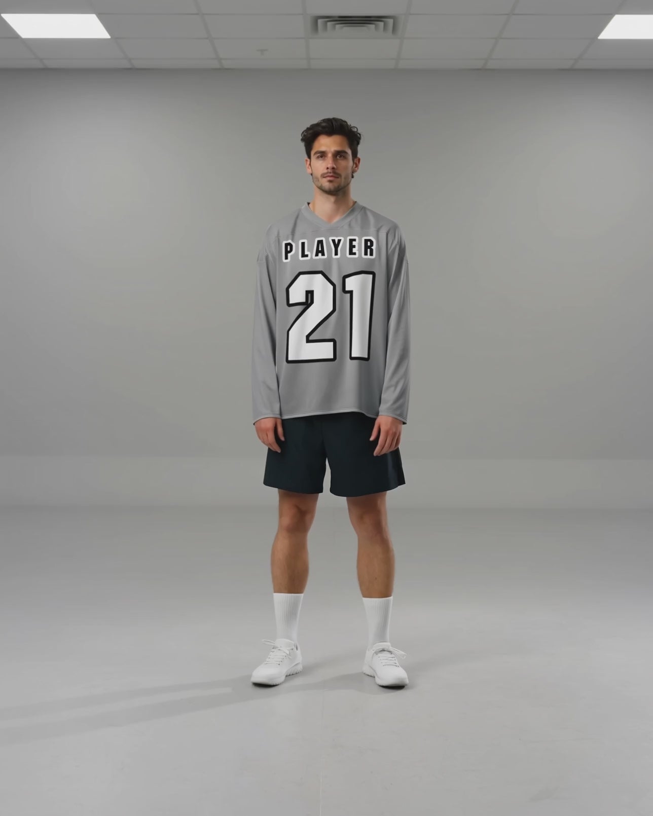 Noah bewegt sich im hellgrauen PLAYER-21-Hockeytrikot und zeigt den Fall von Rumpf und Ärmeln.