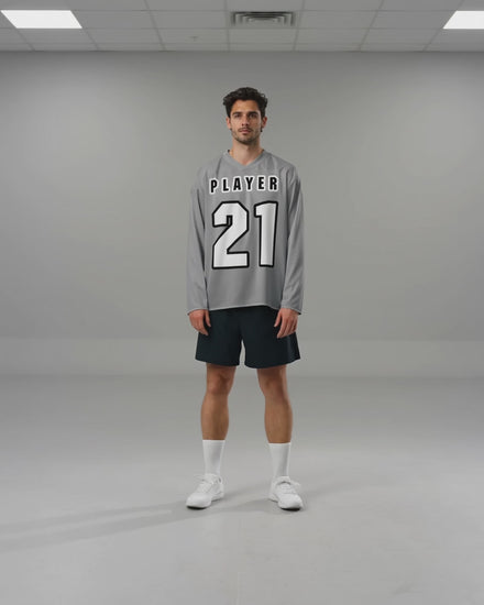 Noah bewegt sich im hellgrauen PLAYER-21-Hockeytrikot und zeigt den Fall von Rumpf und Ärmeln.